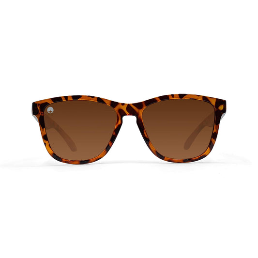 Sunčane naočale SPICY CLASSIC BROWN YELLOW TORTOISE imaju klasičan okvir u stilu Wayfarera sa smeđim gradijentnim polariziranim lećama. Ove unisex sunčane naočale prikazane su na običnoj bijeloj pozadini.