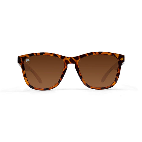 Sunčane naočale SPICY CLASSIC BROWN YELLOW TORTOISE imaju klasičan okvir u stilu Wayfarera sa smeđim gradijentnim polariziranim lećama. Ove unisex sunčane naočale prikazane su na običnoj bijeloj pozadini.